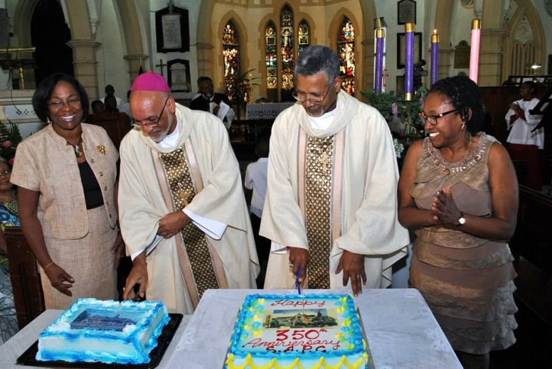 Archbishop Holder (second right) and Diocesan Bishop, Howard Gregory cut the special Anniversary cakes to the delight of Miss Rhena Williams (left) People's Warden and Miss Valda Ormsby, Treasurer
