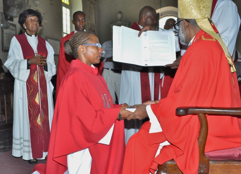 Rev. Khaliah Kinkead receives a Bible from Bishop Robert Thompson at her ordination.