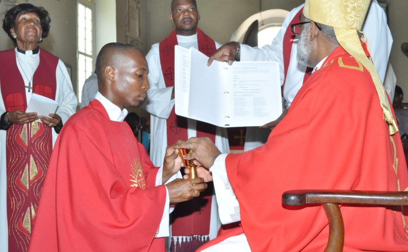 Rev. Larius Lewis receives a chalice from Bishop Robert Thompson at his ordination.
