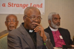 Archdeacon Edmund Davis listens pensively as his Citation is read. In the background are: Archdeacon Winston Thomas, Secretary of Synod; and the Rt. Rev. Robert Thompson, Suffragan Bishop of Kingston.